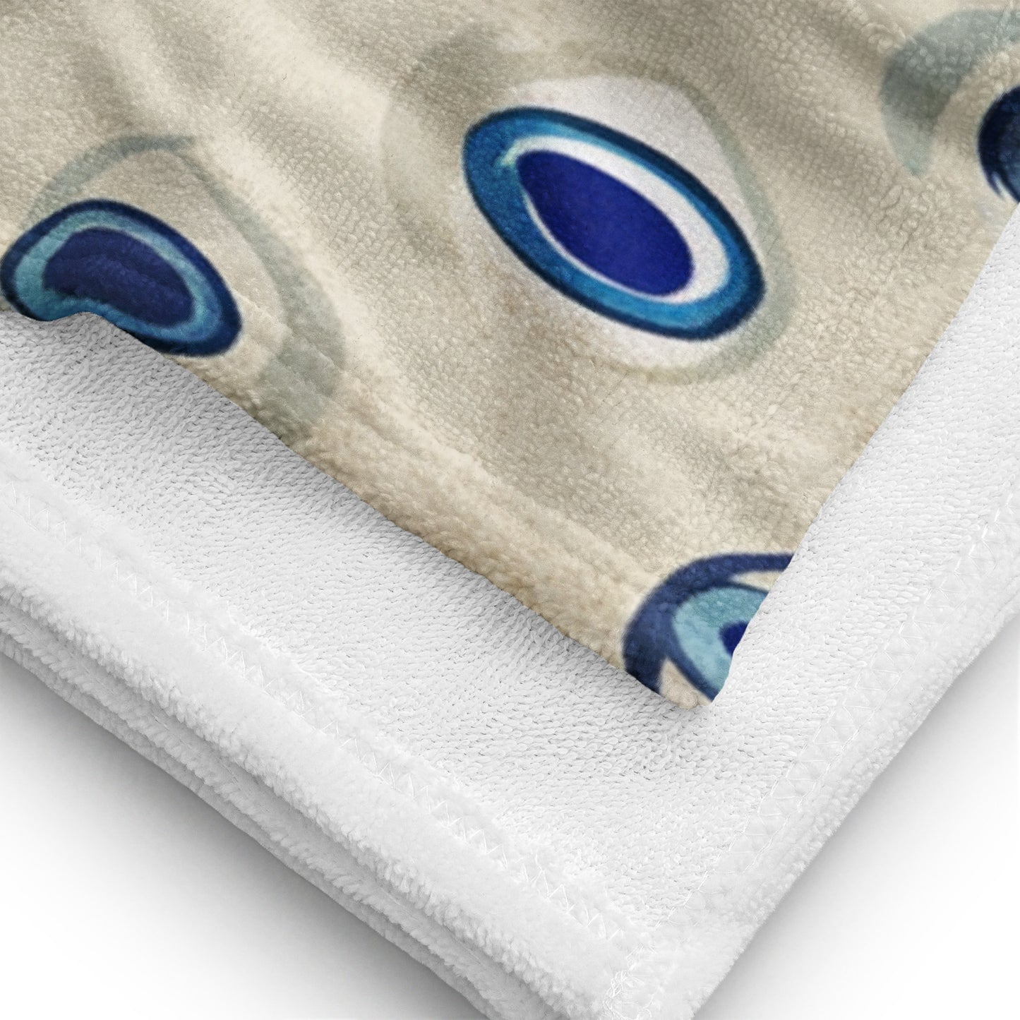 Close-up of a sublimated towel showcasing its detailed texture and a vibrant abstract design with blue oval patterns on a beige background
