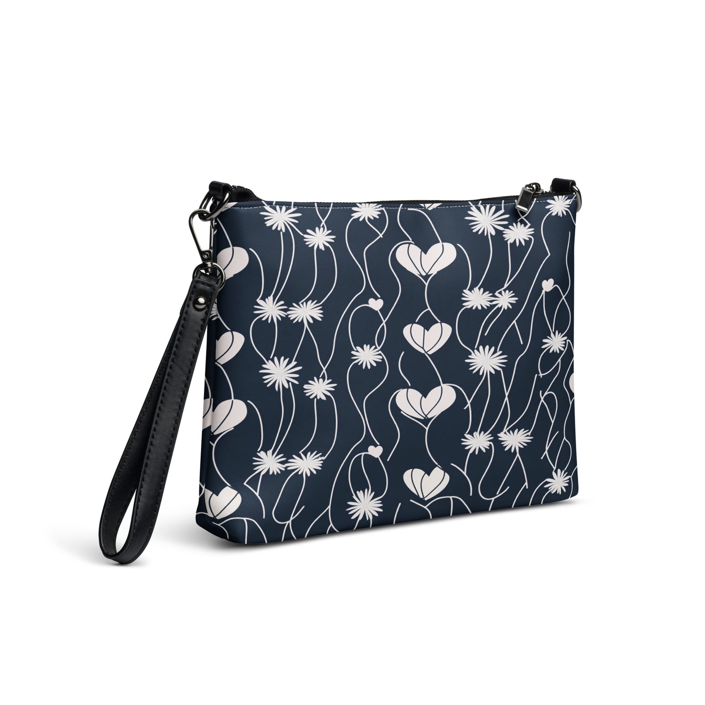 Black crossbody bag featuring white floral heart and daisy pattern with a detachable wrist strap.