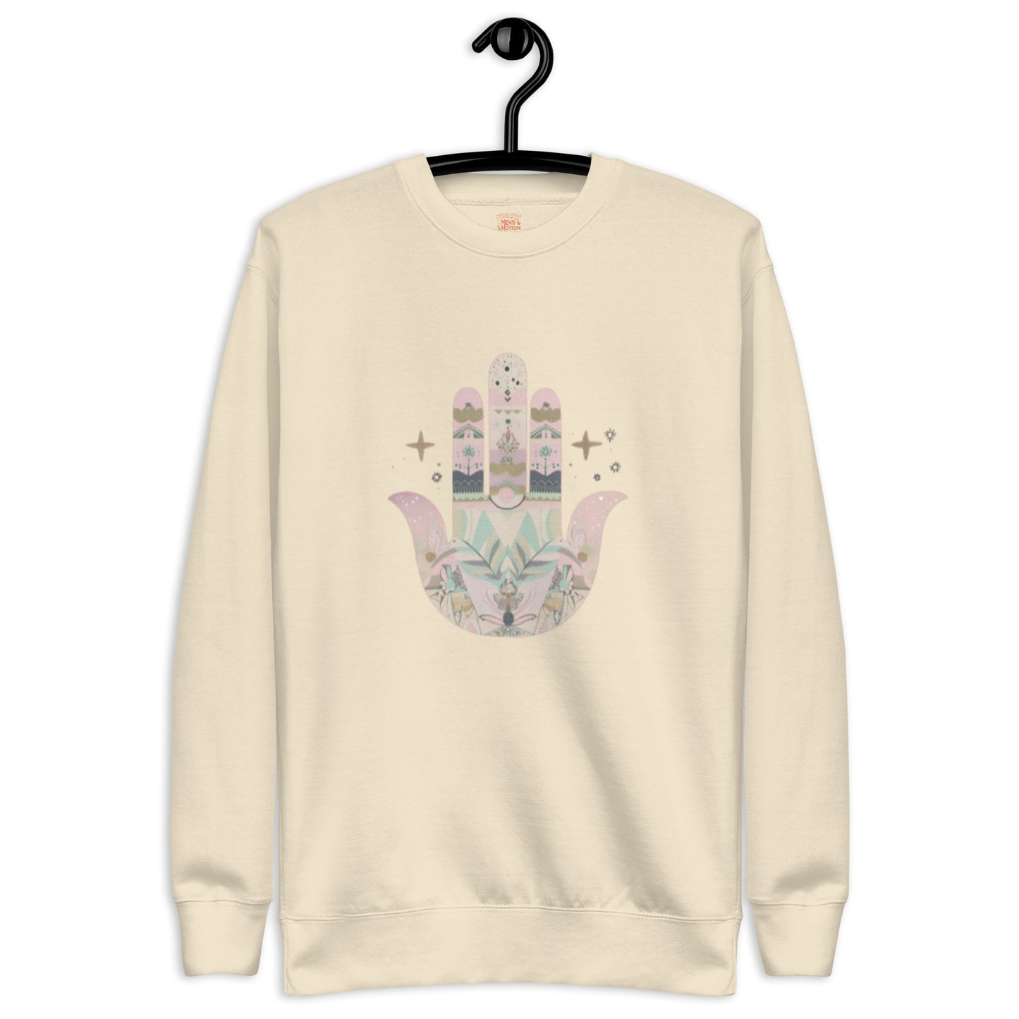 A light bone-colored sweatshirt featuring a pastel-colored Hamsa hand design with floral and geometric elements, displayed on a hanger.