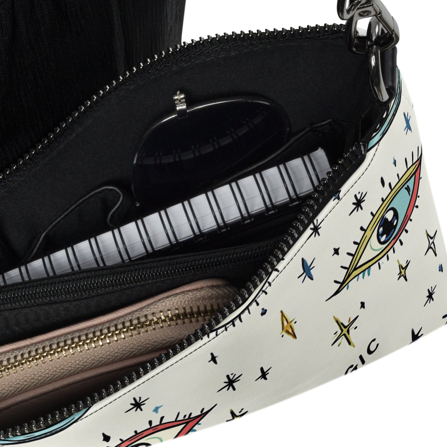 Close-up of celestial-themed crossbody bag interior, featuring organized compartments for sunglasses, a wallet, and other essentials
