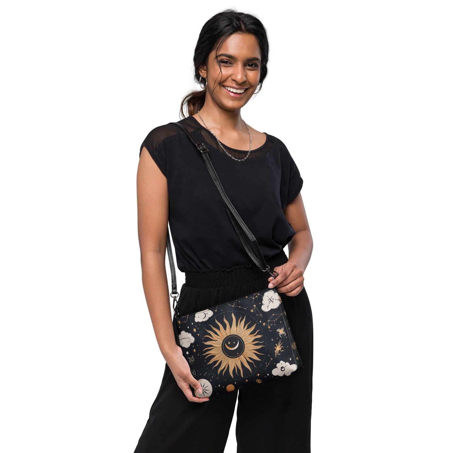 Woman holding a black crossbody bag with celestial sun, moon, and star design, perfect for mindful and stylish accessories