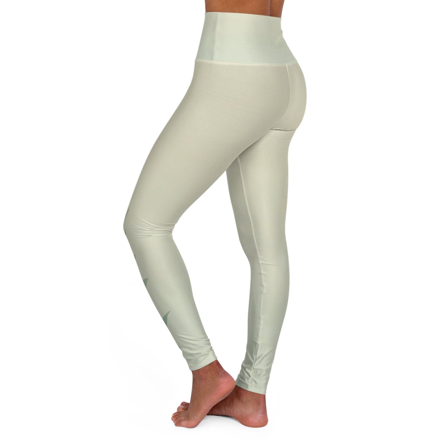Side view of high-waisted leggings in light green, showcasing the sleek fit and leaf print on the right leg.