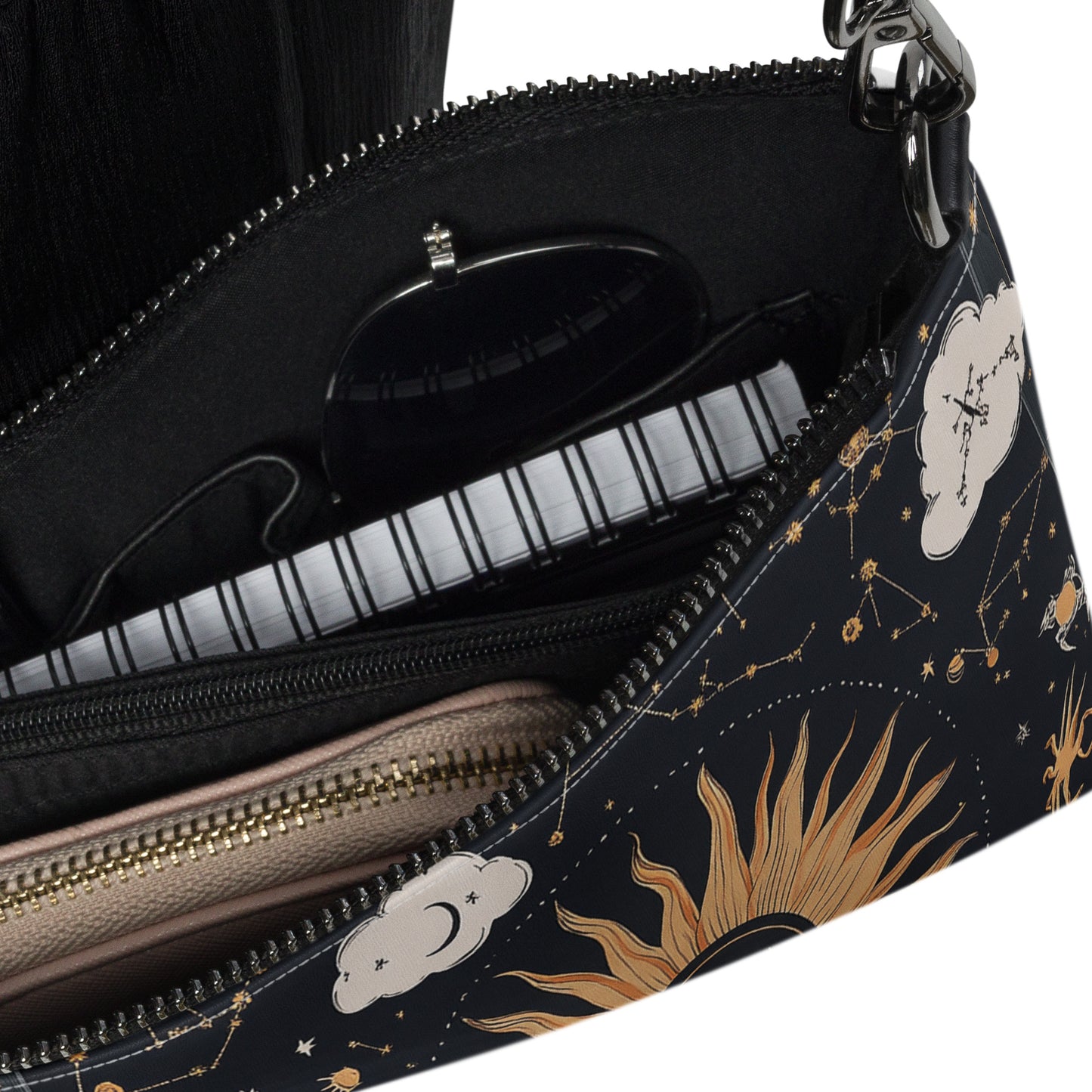 Close-up of the bag's interior with a zipper pocket, glasses, and small notebook, showcasing its organized space
