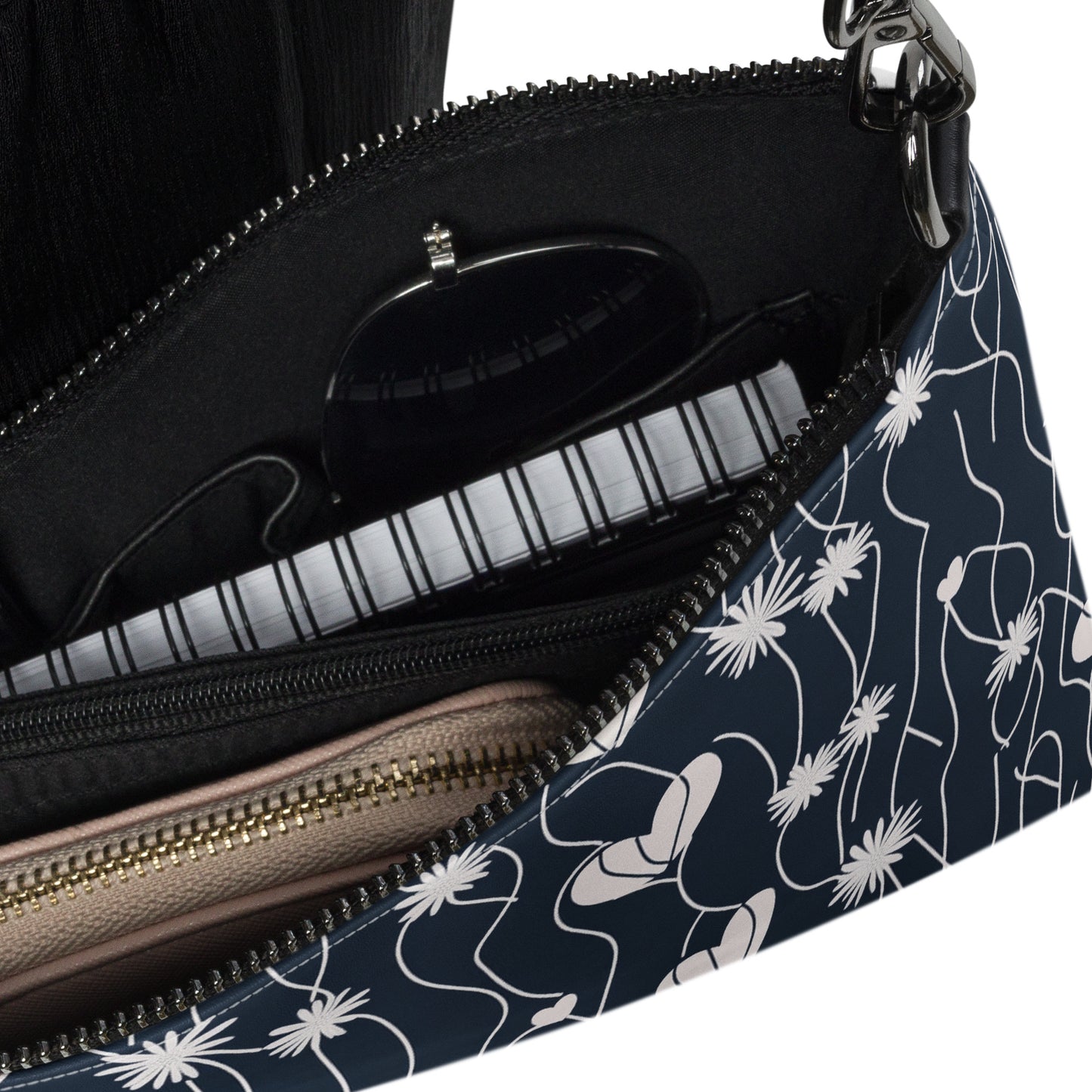 Inside view of Mend & Motion crossbody bag showcasing compartments with sunglasses, a notebook, and a wallet.