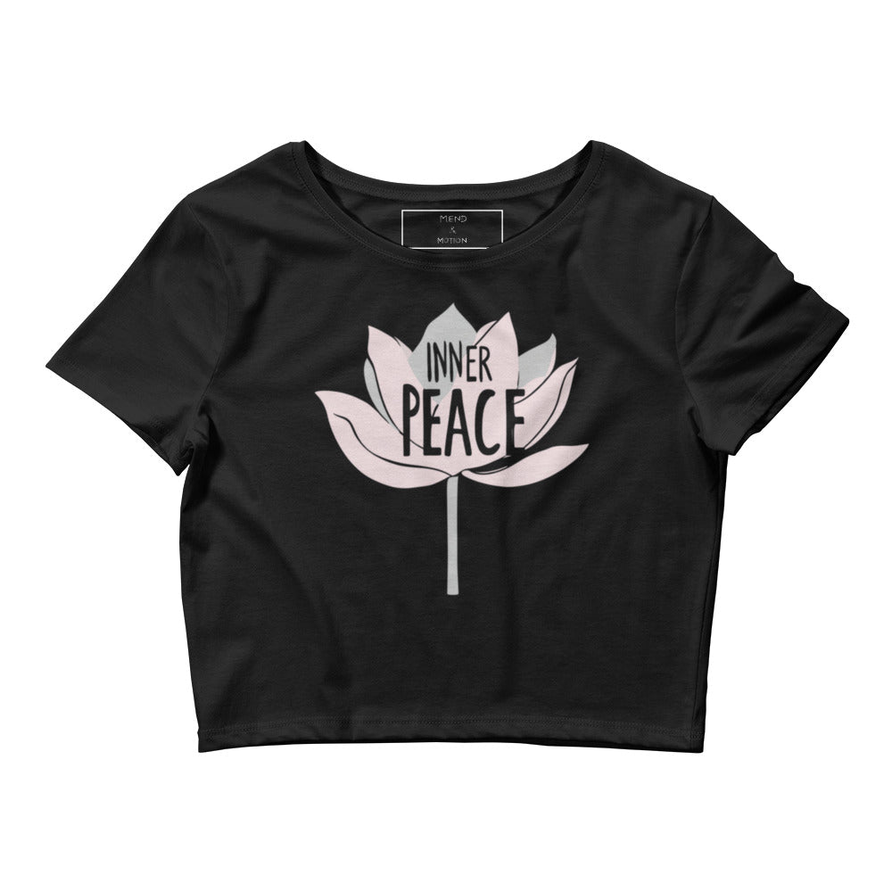 A flat-lay image of a black crop tee showcasing a centered lotus design and the text "Inner Peace."