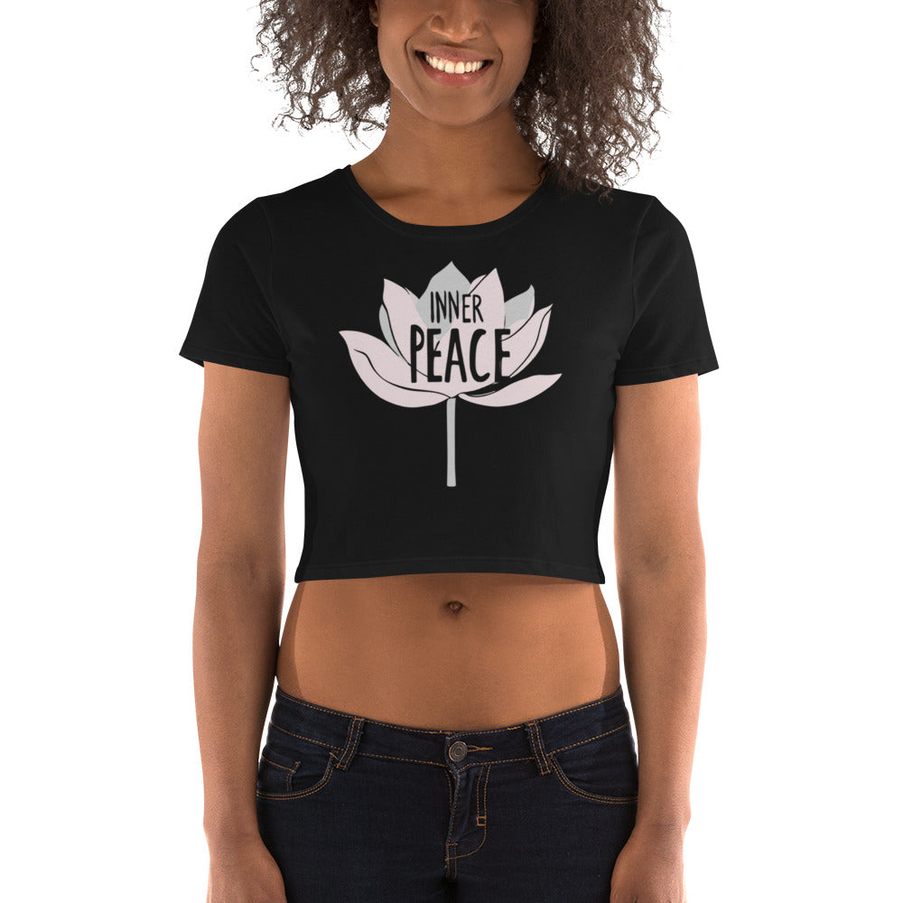 A black crop tee featuring a stylized lotus design with the words "Inner Peace," modeled by a smiling woman.
