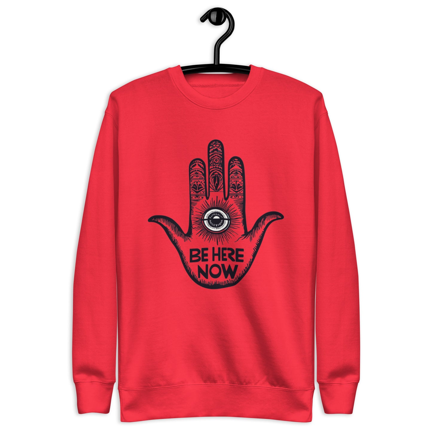 Red sweatshirt featuring a hand design with intricate patterns and the phrase 'Be Here Now' at the center