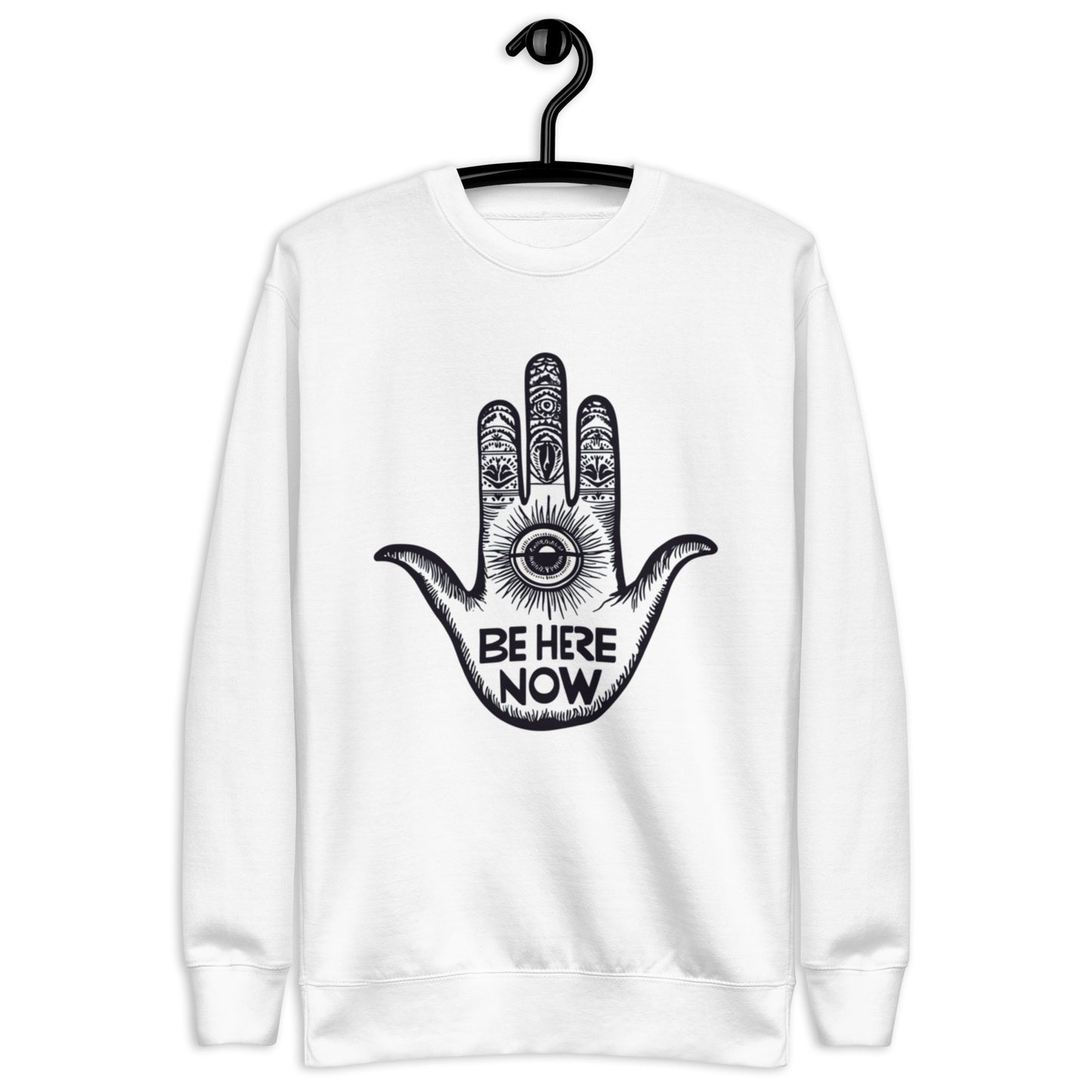 White sweatshirt featuring a creative hand design and the text 'Be Here Now' in eye-catching black print