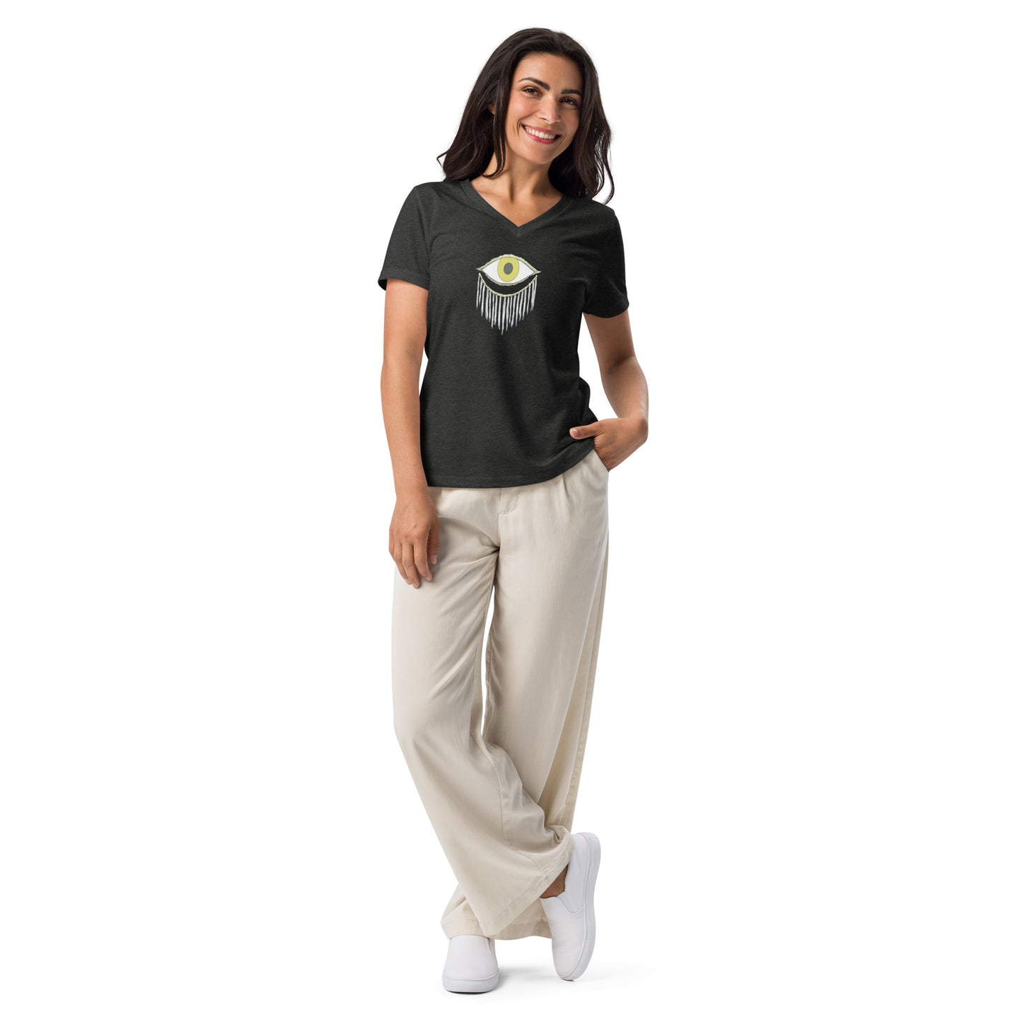 Model wearing a black V-neck T-shirt with an abstract eye and fringes design, paired with beige trousers and white sneakers