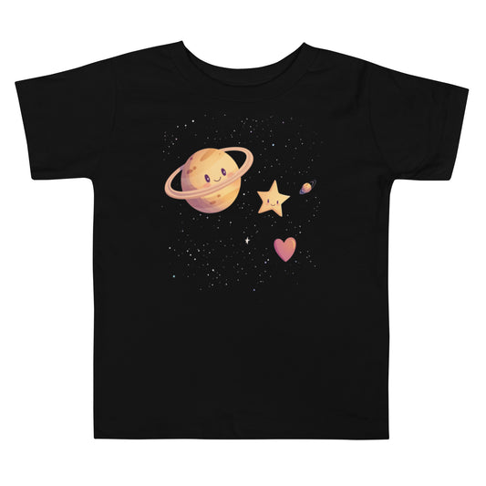 A black toddler T-shirt featuring a whimsical design with a smiling Saturn, a cheerful star, a heart, and a mini planet surrounded by twinkling stars.