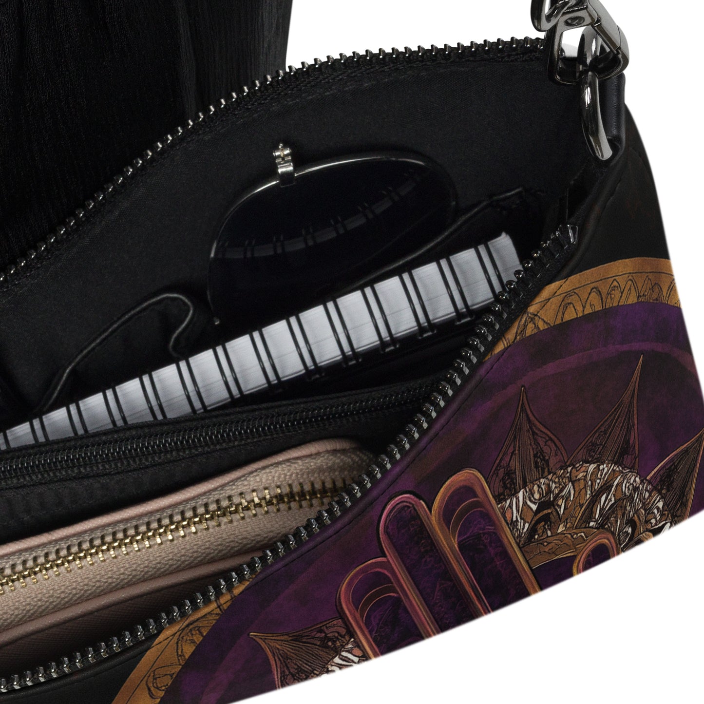 Close-up of a crossbody bag interior showing compartments and a glimpse of the artistic purple and gold design on the side