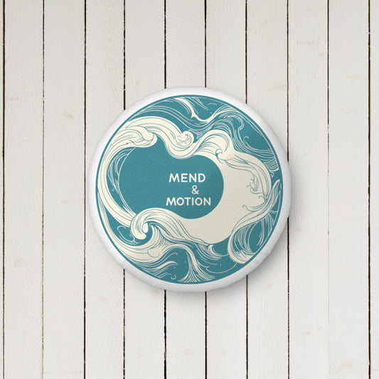 A round decorative pillow featuring an ocean wave-inspired design in teal and cream, with the "Mend & Motion" logo elegantly centered.