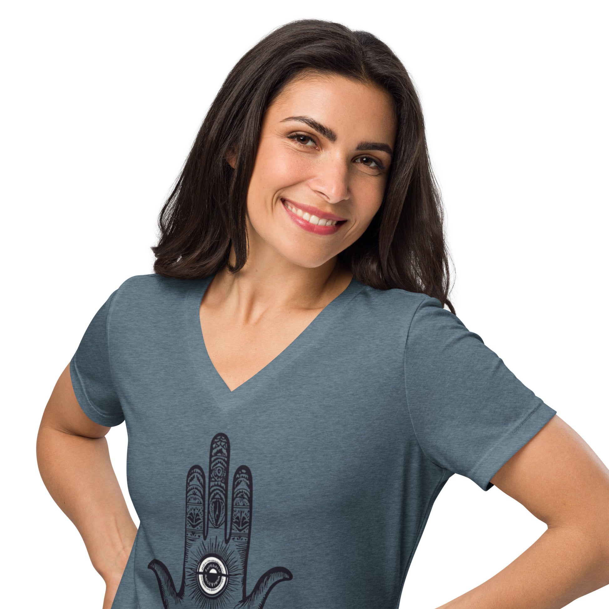 Smiling woman wearing a slate v-neck t-shirt with a "Be Here Now" hand design featuring an eye and patterns