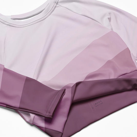 A close-up flat lay of a purple gradient long sleeve crop top with soft, smooth fabric and stitching details.