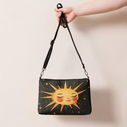  Black crossbody bag featuring a radiant sun design with cheerful details, held by a hand