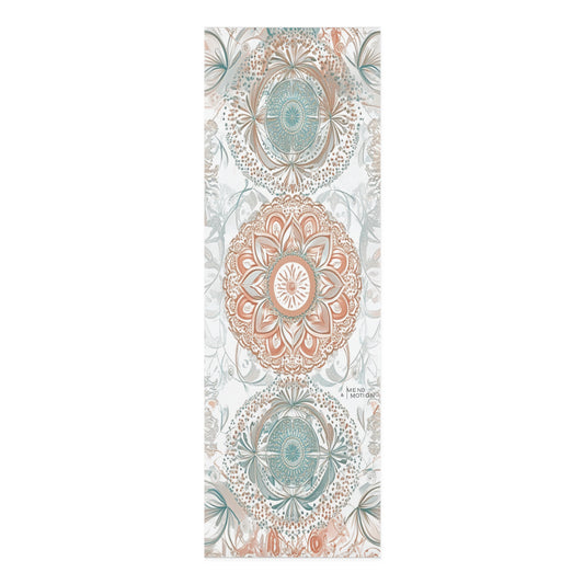 Full view of a yoga mat with intricate mandala patterns in teal and beige tones
