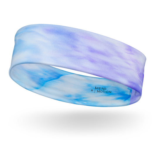 Soft tie-dye headband in shades of sky blue and lavender with "Mend & Motion" logo, showcasing seamless fit and vibrant colors